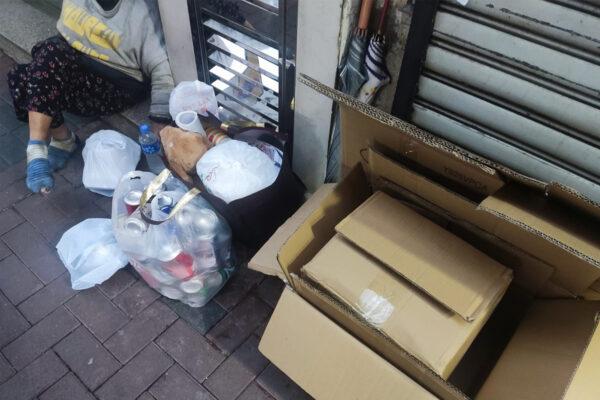 The Epoch Times reporters went to Ivy Street again on the evening of April 20, 2023, to visit Ms Chan. Next to her are the boxes and cans she collected during the day. (Lin Jianxiang/ The Epoch Times)