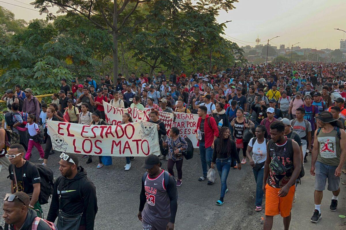 Migrants from Central and South America take part in a caravan heading toward the U.S.–Mexico border, while carrying signs protesting the death of 40 migrants in a fire at a Mexican detention center, in Tapachula, Mexico, on April 23, 2023. (AFP via Getty Images)