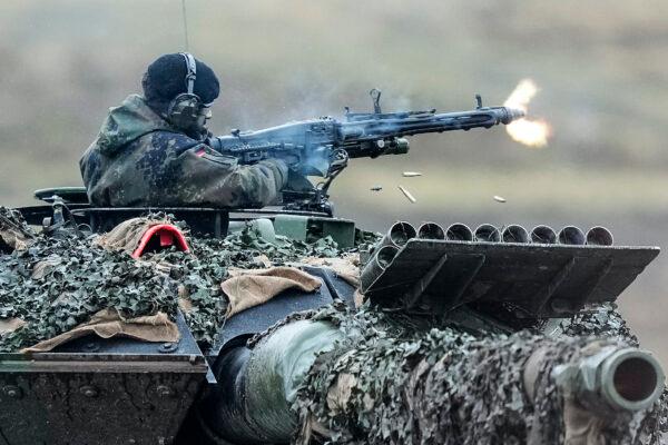 A soldier fires a machine gun from a Leopard 2 tank at the Bundeswehr tank battalion 203 at the Field Marshal Rommel Barracks in Augustdorf, Germany, on Feb. 1, 2023. (Martin Meissner/AP Photo)