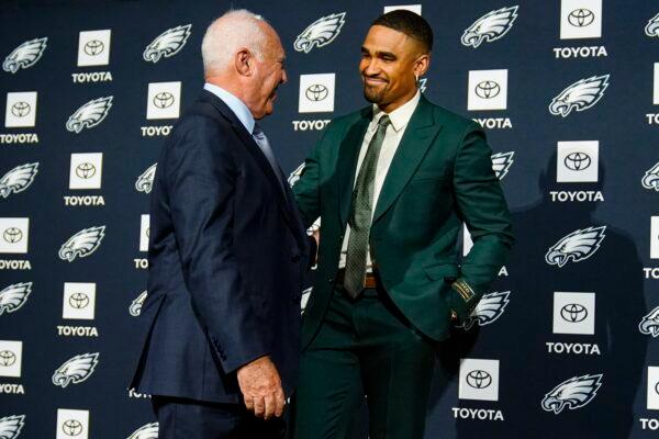 Philadelphia Eagles owner Jeffrey Lurie and quarterback Jalen Hurts move to poses for photographs during a news conference at the NFL football team's training facility in Philadelphia on April 24, 2023. (Matt Rourke/AP Photo)