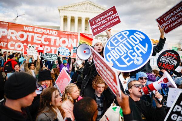 Pro-life and pro-abortion activists hold signs with opposing views during the 50th annual March for Life rally in front of the U.S. Supreme Court in Washington on Jan. 20, 2023. (Chip Somodevilla/Getty Images)