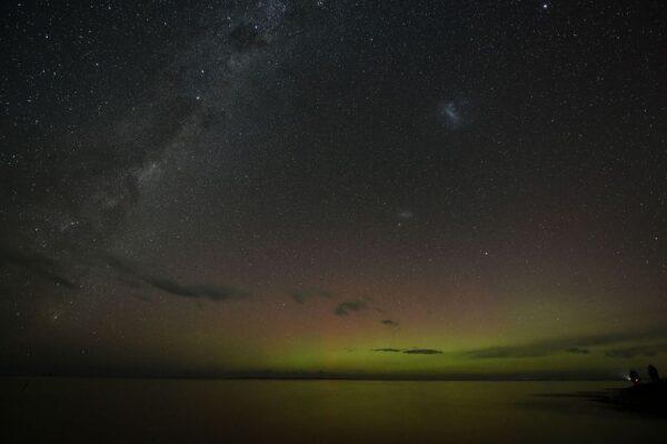The Aurora Australis, also known as the Southern Lights, glow on the horizon over waters of Lake Ellesmere on the outskirts of Christchurch on April 24, 2023. (Sanka Vidanagama/AFP via Getty Images)