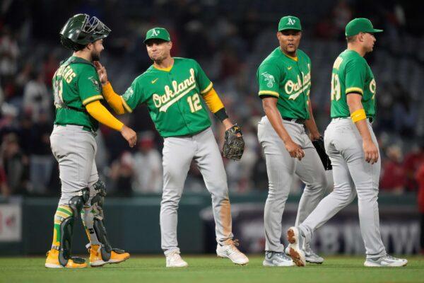Oakland Athletics catcher Shea Langeliers (23), third baseman Aledmys Diaz (12), relief pitcher Jeurys Familia (31), and first baseman Ryan Noda (49) celebrate a victory over the Los Angeles Angels in Anaheim, Calif., on April 24, 2023. (Ashley Landis/AP Photo)