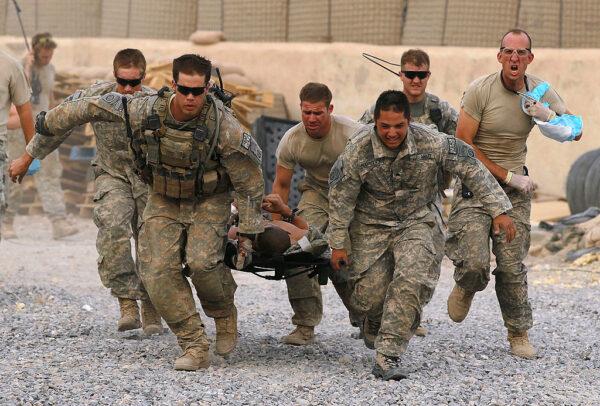  U.S. Army soldiers carry a critically wounded American soldier on a stretcher to an awaiting MEDEVAC helicopter from Charlie Co. Sixth Battalion, 101st Airborne Combat Aviation Brigade, Task Force Shadow, near Kandahar, Afghanistan, on June 24, 2010. (Justin Sullivan/Getty Images)