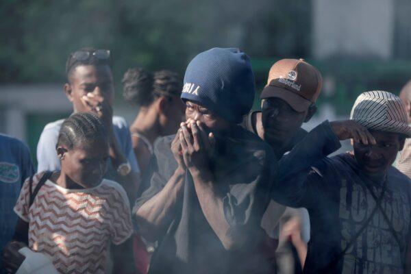 Bystanders look at the bodies of alleged gang members that were set on fire by a mob after they were stopped by police while traveling in a vehicle in the Canape Vert area of Port-au-Prince, Haiti, on April 24, 2023. (Odelyn Joseph/AP Photo)