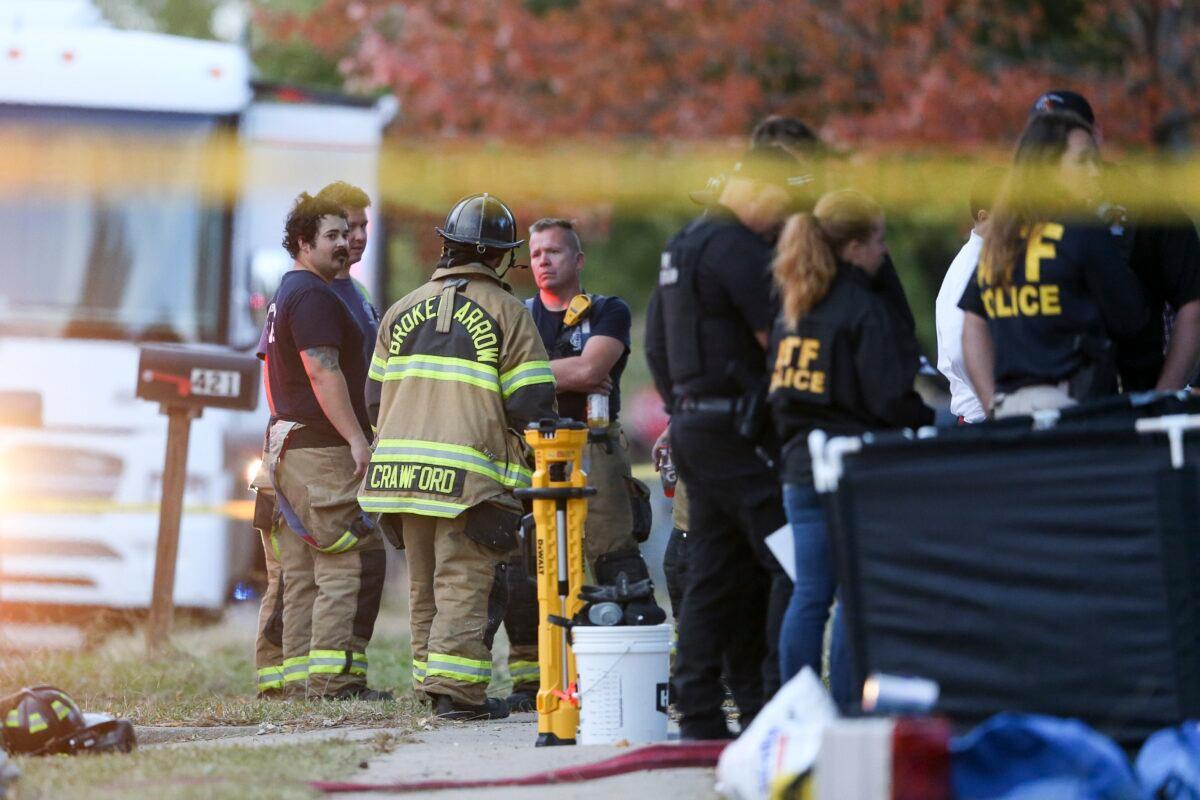 Police and firefighters investigate the scene of a house fire with multiple fatalities in Broken Arrow, Okla., on Oct. 27, 2022. (Ian Maule/Tulsa World via AP)