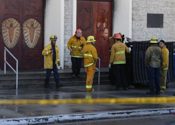 Firefighters and arson investigators inspect the damaged Resurrection Catholic Church after an arson and vandalism attack in Los Angeles on Jan. 25, 2018. (MARK RALSTON/AFP via Getty Images)