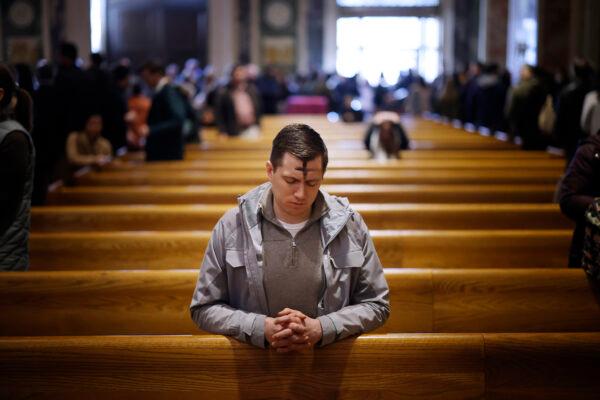 With a cross of ash on his forehead, a man prays following an Ash Wednesday Mass at the Cathedral of St. Matthew the Apostle in Washington on Feb. 22, 2023. (Chip Somodevilla/Getty Images)