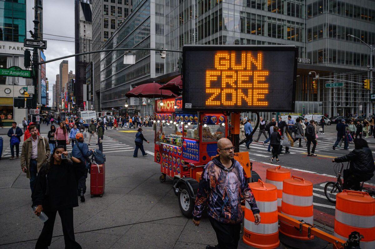 Pedestrians pass a "gun-free zone" sign in New York on Oct. 13, 2022. (Ed Jones/AFP via Getty Images)