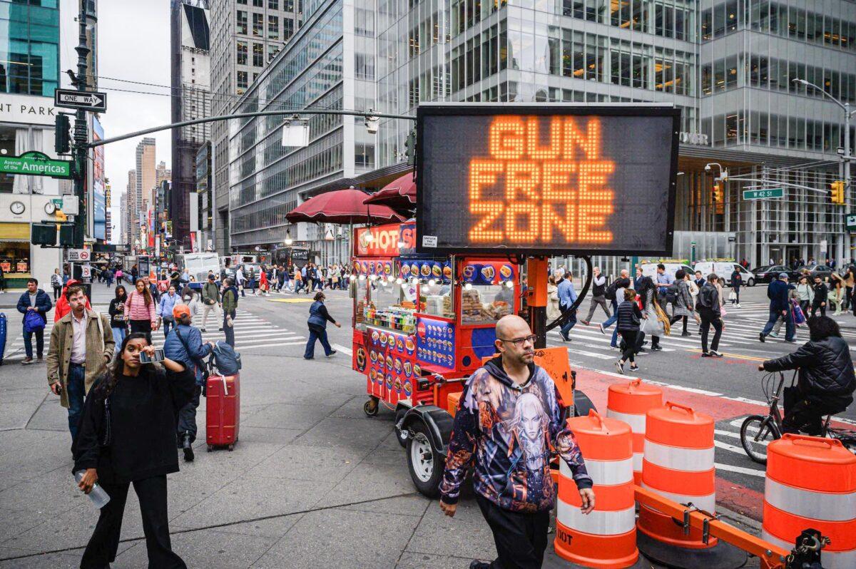 Pedestrians pass an anti-gun sign in New York city on Oct. 13, 2022. (Ed Jones/AFP via Getty Images)