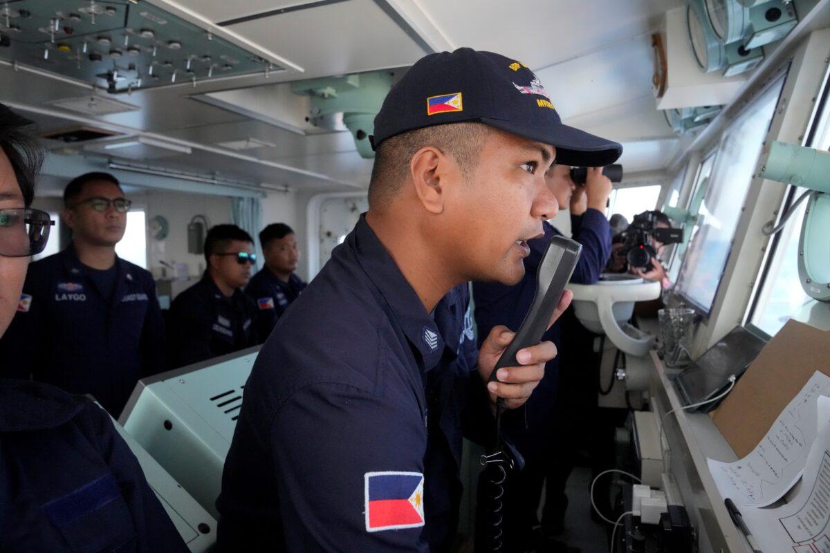 Philippine Coast Guard Petty Officer 3 John Solatre uses the radio on board the BRP Malabrigo to send a message to suspected Chinese militia ships near the Philippine-claimed Island of Thitu, locally known as Pag-asa island, at the South China Sea on April 21, 2023. (Aaron Favila/AP Photo)