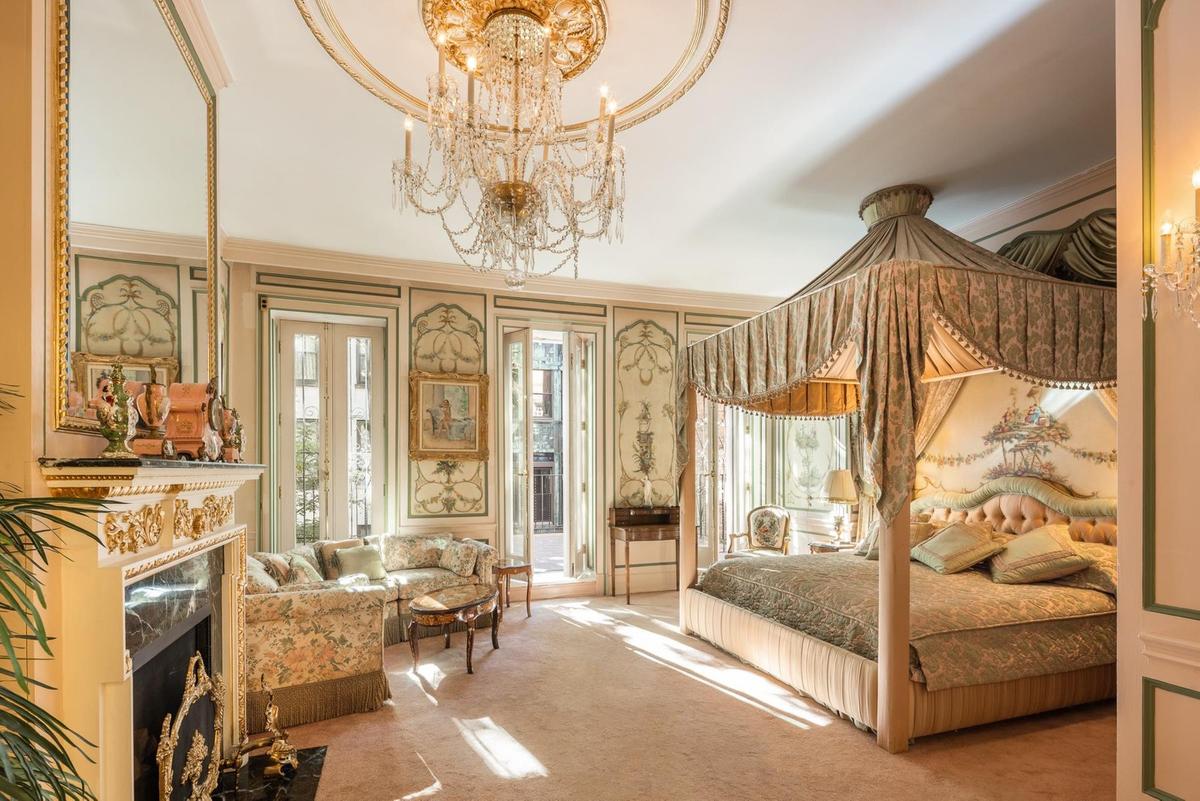 The airy master bedroom, straight out of a fairy tale, features a shimmering chandelier overhead and a roaring fireplace ready to chase away the chill. (Courtesy of Evan Joseph Photography and toptenrealestatedeals.com)