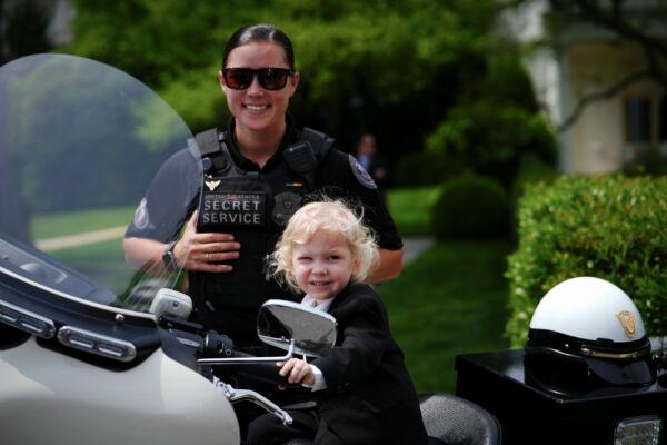 U.S. Secret Services agent (L) and a boy (R) pose during the Take Your Child to Work Day event at the White House in Washington on April 27, 2023. (Madalina Vasiliu/The Epoch Times)