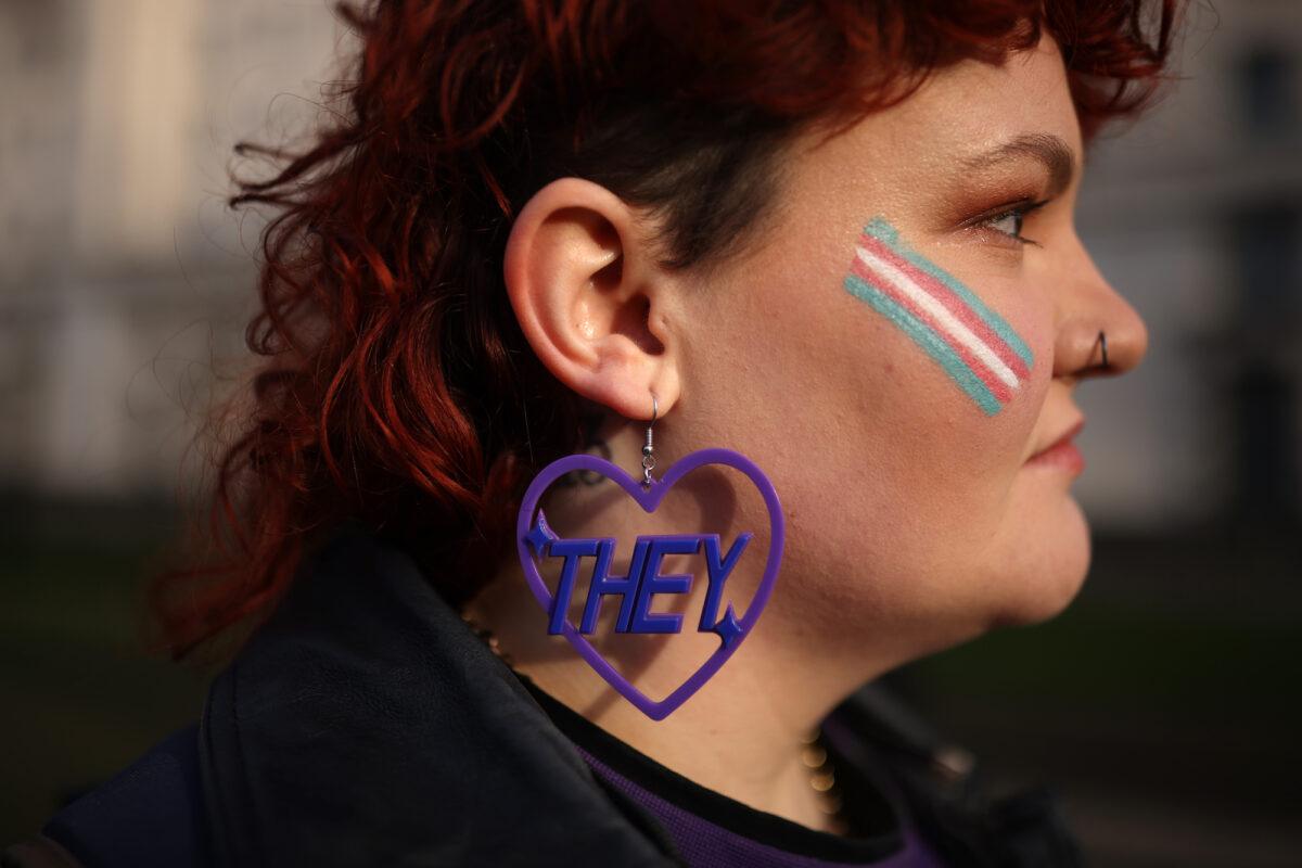 A trans activist wears an earring featuring a "they" pronoun symbol, during a protest outside the Ministry of Defence Main Building in Whitehall in London, on Jan. 17, 2023. (Dan Kitwood/Getty Images)