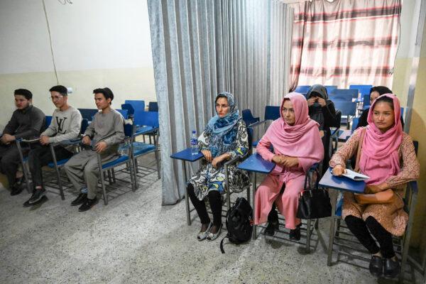 Students attend a class bifurcated by a curtain separating males and females at a private university to follow the Taliban's ruling, in Kabul, Afghanistan, on Sept. 7, 2021. (Aamir Qureshi/AFP via Getty Images)