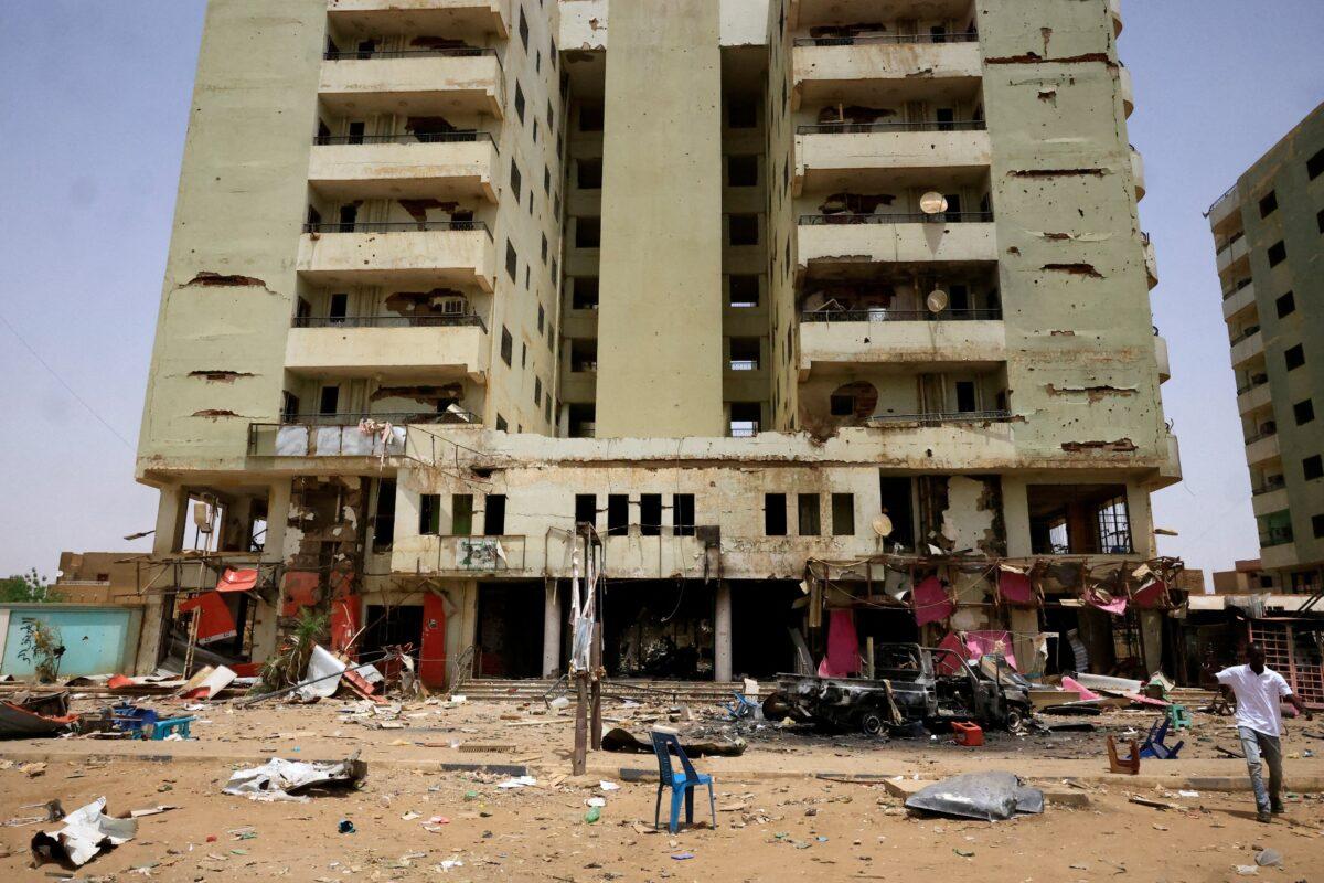 A man walks near a damaged car and buildings at the central market during clashes between the paramilitary Rapid Support Forces and the army in Khartoum North, Sudan on April 27, 2023. (Mohamed Nureldin Abdallah/Reuters)
