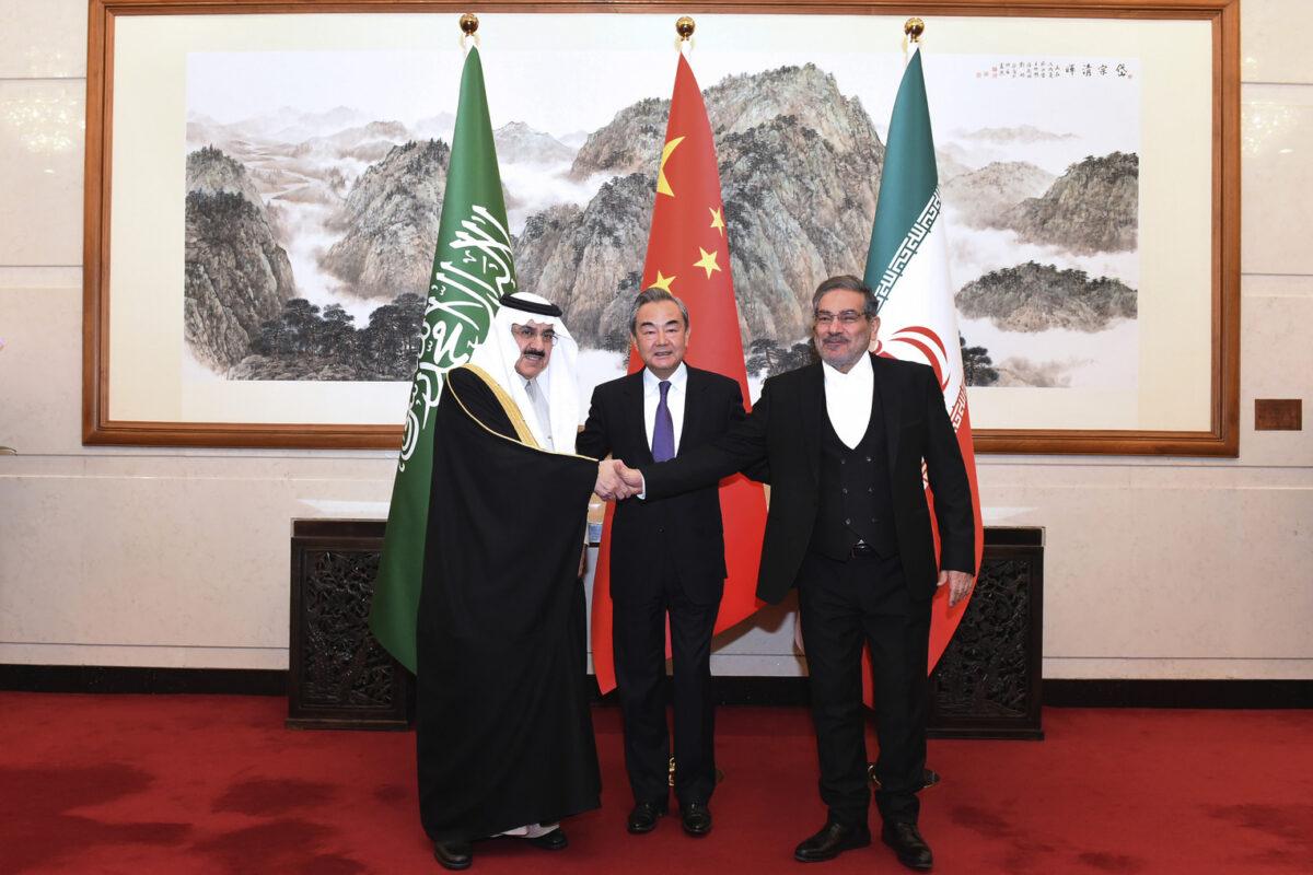Ali Shamkhani, secretary of Iran's Supreme National Security Council (R), shakes hands with Saudi national security adviser Musaad bin Mohammed al-Aiban (L) as Wang Yi, China's most senior diplomat, looks on (C). (Luo Xiaoguang/AP Photo)