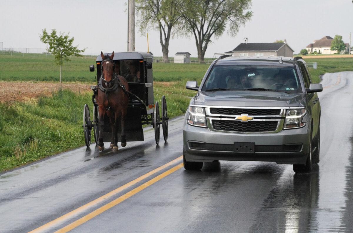 Horse-drawn buggies and modern cars coexist on the roads of Lancaster County, Pa., on April 26, 2023. (Richard Moore/The Epoch Times)