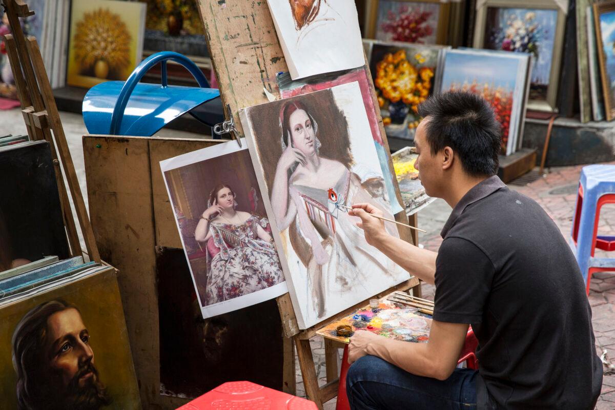 An artist working on his painting outside a gallery at the artist village on June 12, 2014 in Shenzhen, China. (Palani Mohan/Getty images)