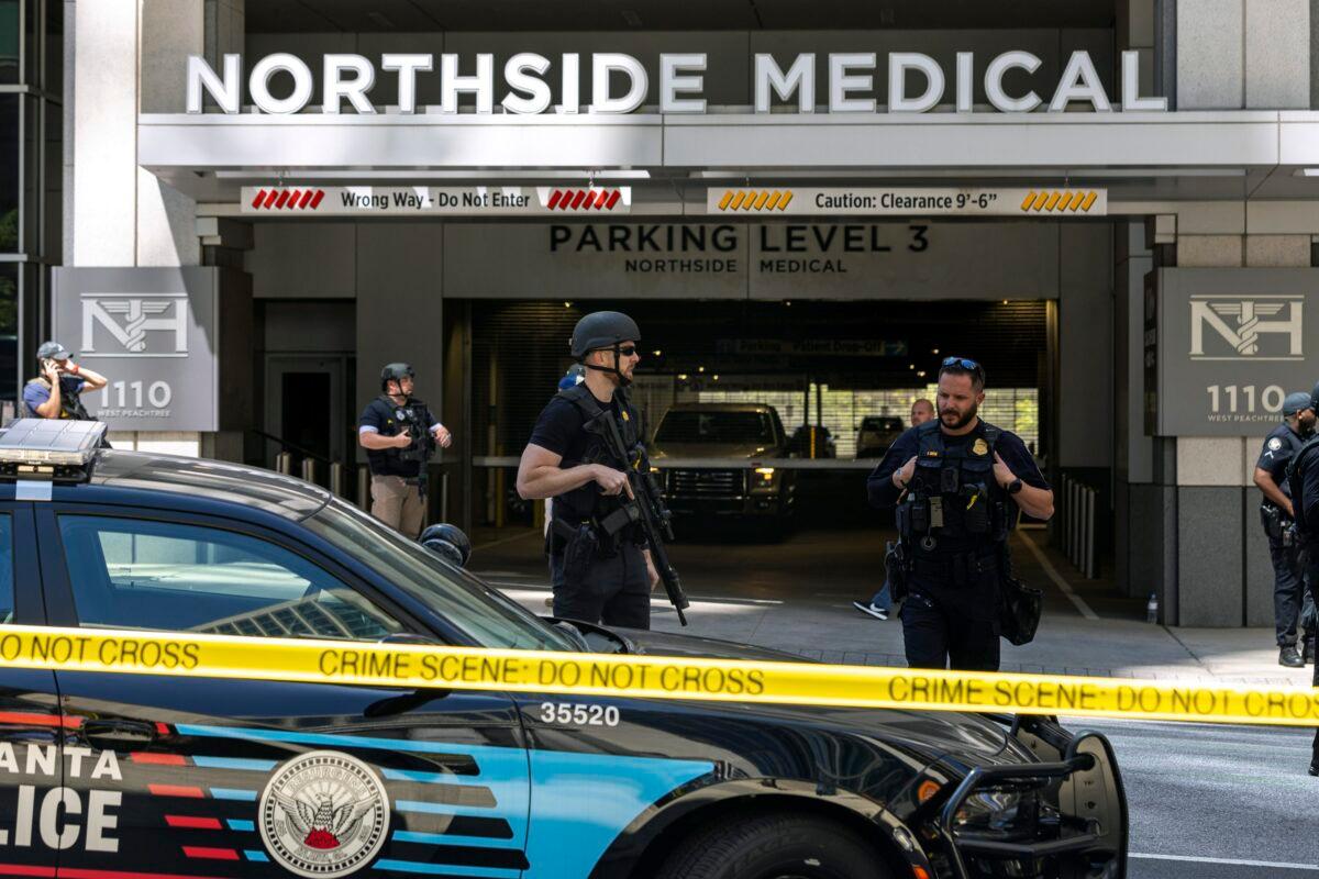 Law enforcement officers stand Northside Hospital Midtown medical office building, where five people were shot in Atlanta on May 3, 2023. (Arvin Temkar/Atlanta Journal-Constitution via AP)
