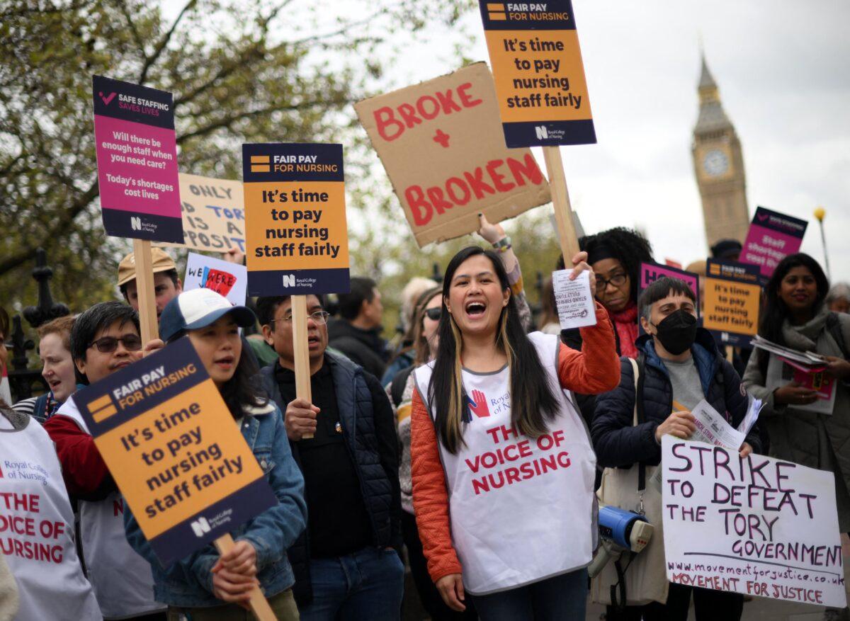 Health care workers hold placards as they demonstrate as members of the Royal College of Nursing continue their industrial action, on Westminster Bridge, near to St. Thomas's Hospital, in London on May 1, 2023. (Daniel Leal/AFP via Getty Images)