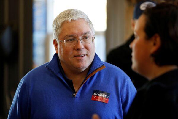 Republican senate nominee Patrick Morrisey speaks with a supporter at a blacksmith's forge ahead of the 2018 midterm elections in Falling Water, W.V., on Nov. 4, 2018. (Joshua Roberts/Reuters)