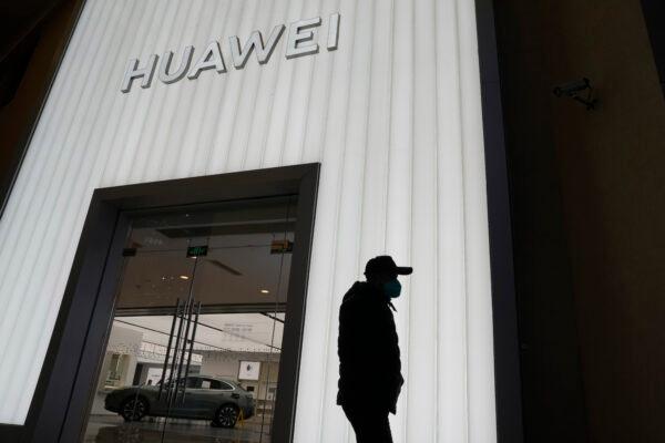 A man outside a Huawei retail store in Beijing on Dec. 30, 2022. (AP-Ng Han Guan/The Canadian Press)