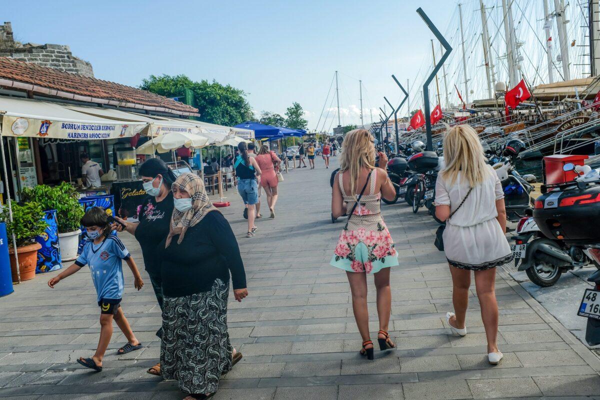 Ukrainian tourists walk next to Turkish locals in Bodrum, southwestern Turkey, on June 16, 2021. (Bulent Kilic/AFP via Getty Images/TNS)