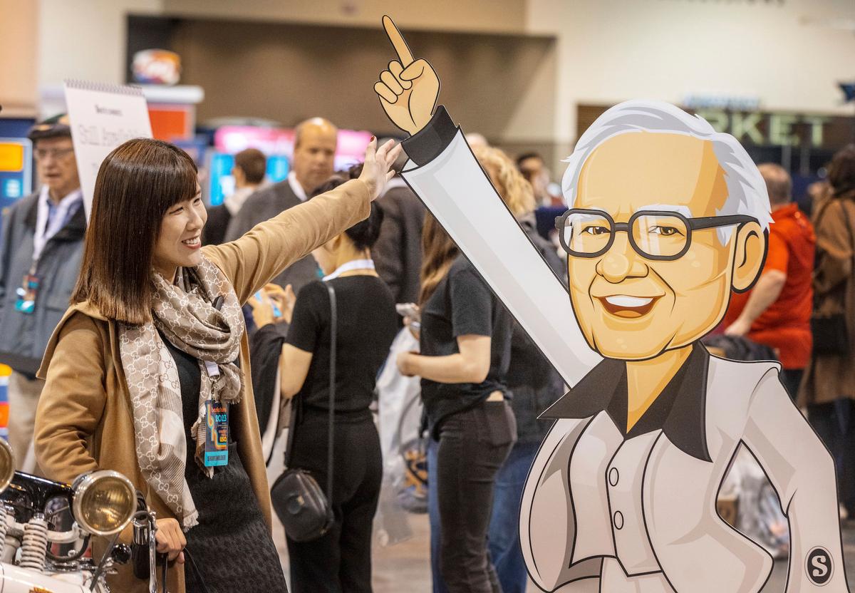 An attendee poses for a photo with a cardboard cutout of Warren Buffett at the Berkshire Hathaway annual meeting in Omaha, Nebraska, on May 5, 2023. (Chris Machian/Omaha World-Herald via AP)