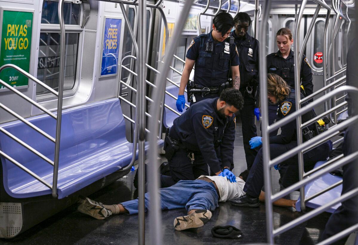 New York police officers administer CPR to Jordan Neely on a subway train in N.Y.C., on May 1, 2023. (Paul Martinka via AP)