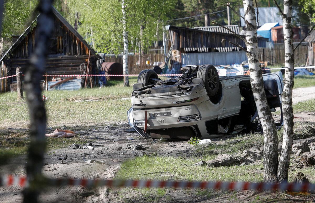 A damaged white Audi Q7 car lying overturned on a track next to a wood, after Russian nationalist writer Zakhar Prilepin was allegedly wounded in a bomb attack in a village in the Nizhny Novgorod region, Russia, on May 6, 2023. (Anastasia Makarycheva/Reuters)