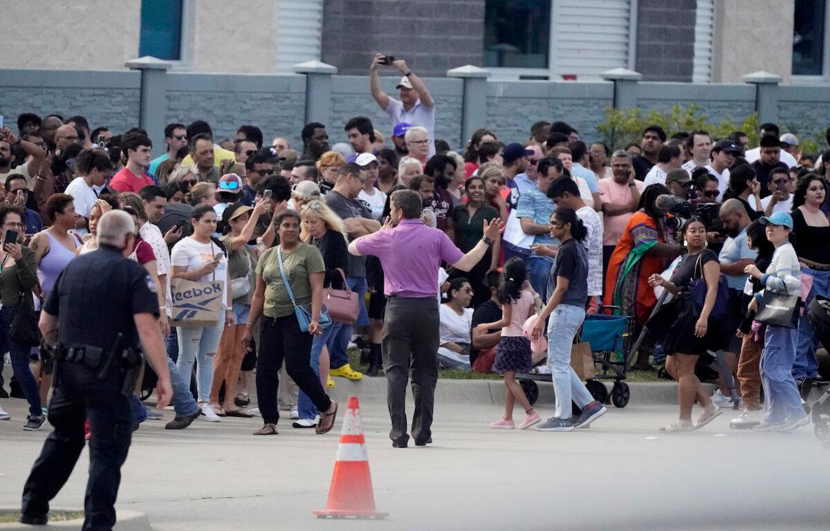 People gather across the street from a shopping center after a shooting in Allen, Texas, on May 6, 2023. (AP Photo/LM Otero)