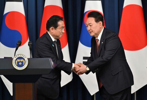 South Korean President Yoon Suk Yeol, right, shakes hands with Japanese Prime Minister Fumio Kishida during a joint press conference after their meeting at the presidential office in Seoul, on May 7, 2023. (Jung Yeon-je/Pool Photo via AP)