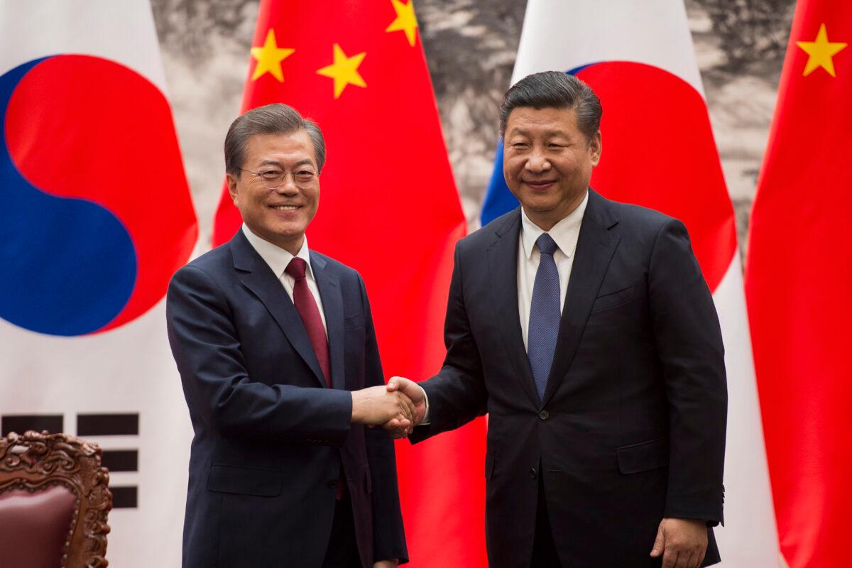 South Korean President Moon Jae-In (L) and Chinese leader Xi Jinping (R) shake hands at the end of a signing ceremony at the Great Hall of the People, in Beijing, China, on Dec. 14, 2017. (Nicolas Asfouri-Pool/Getty Images)