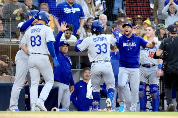 Manager Dave Roberts, Will Smith (16), and Michael Busch (83) congratulates James Outman (33) of the Los Angeles Dodgers after his two run home-run during the tenth inning of a game against the San Diego Padres at PETCO Park in San Diego on May 7, 2023. (Sean M. Haffey/Getty Images)