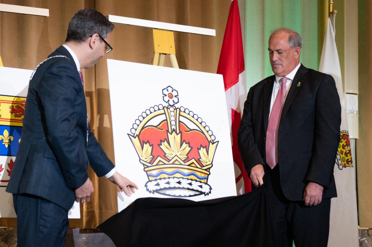The Royal crown is unveiled by Samy Khalid (L), Chief Herald of Canada at the Canadian Heraldic Authority, and Donald Booth, Canadian secretary to the King, during coronation celebrations in honour of King Charles III in Ottawa on May 6, 2023. (The Canadian Press/Spencer Colby)