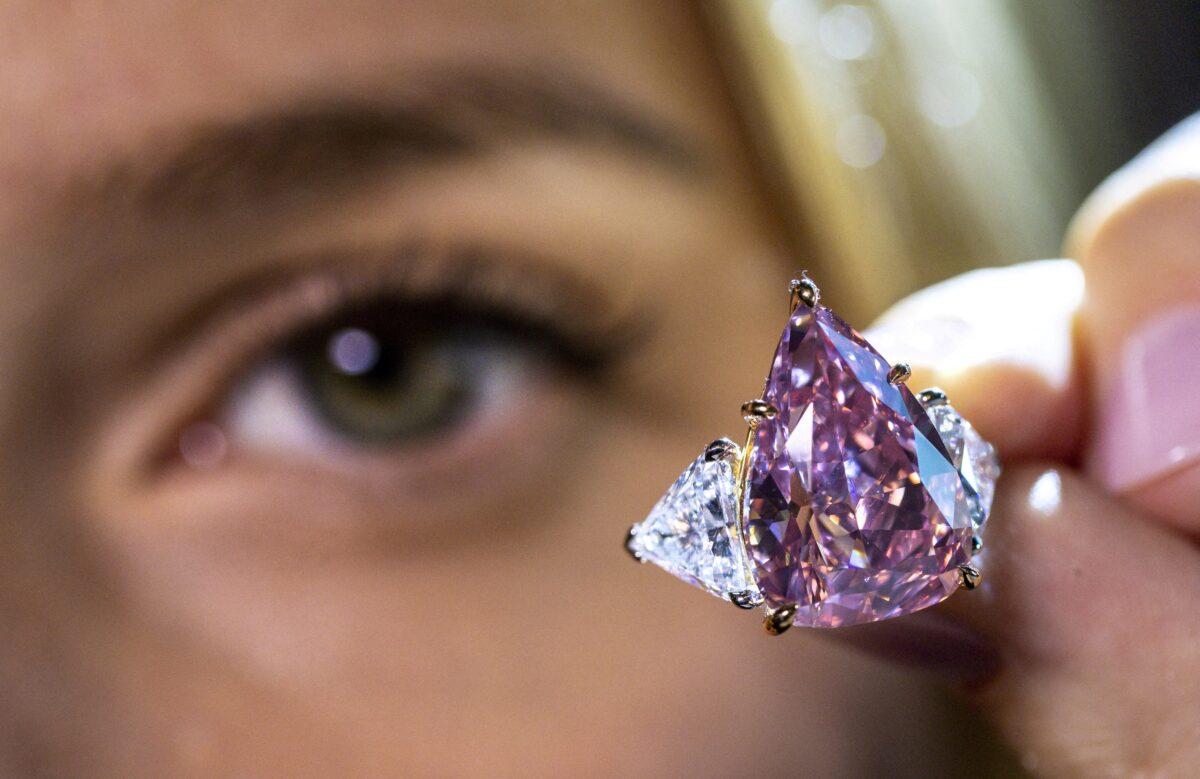 A model holds a 18.18-carat pink diamond called "Fortune Pink" that could fetch $30 million during a preview at Christie’s before the auction sale in Geneva on Nov. 2, 2022. (Denis Balibouse/Reuters)