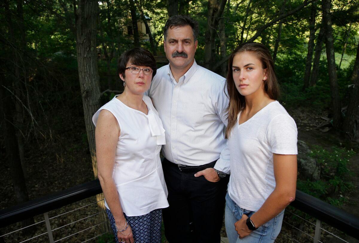 (L–R) Family members of 18-year-old murder victim Andrew Oneschuk, mother, Chris; father, Walter; and sister, Emily, stand for a portrait at their home in Wakefield, Mass., on Aug. 9, 2017. (Steven Senne/AP Photo)