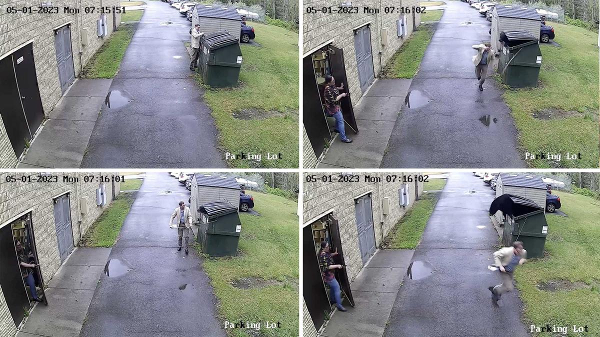 CCTV shows Zela Elementary School principal, James Marsh, opening the school's dumpster and finding a black bear hiding inside. (Screenshot/Newsflare)