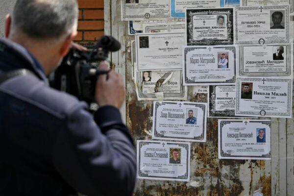 A cameraman films memorial placards of five young men killed in a drive-by shooting in the village of Malo Orasje near the town of Mladenovac, about 60 kilometres (37 miles) south of Serbia's capital Belgrade, on May 6, 2023. (Andrej Isakovic/AFP via Getty Images)