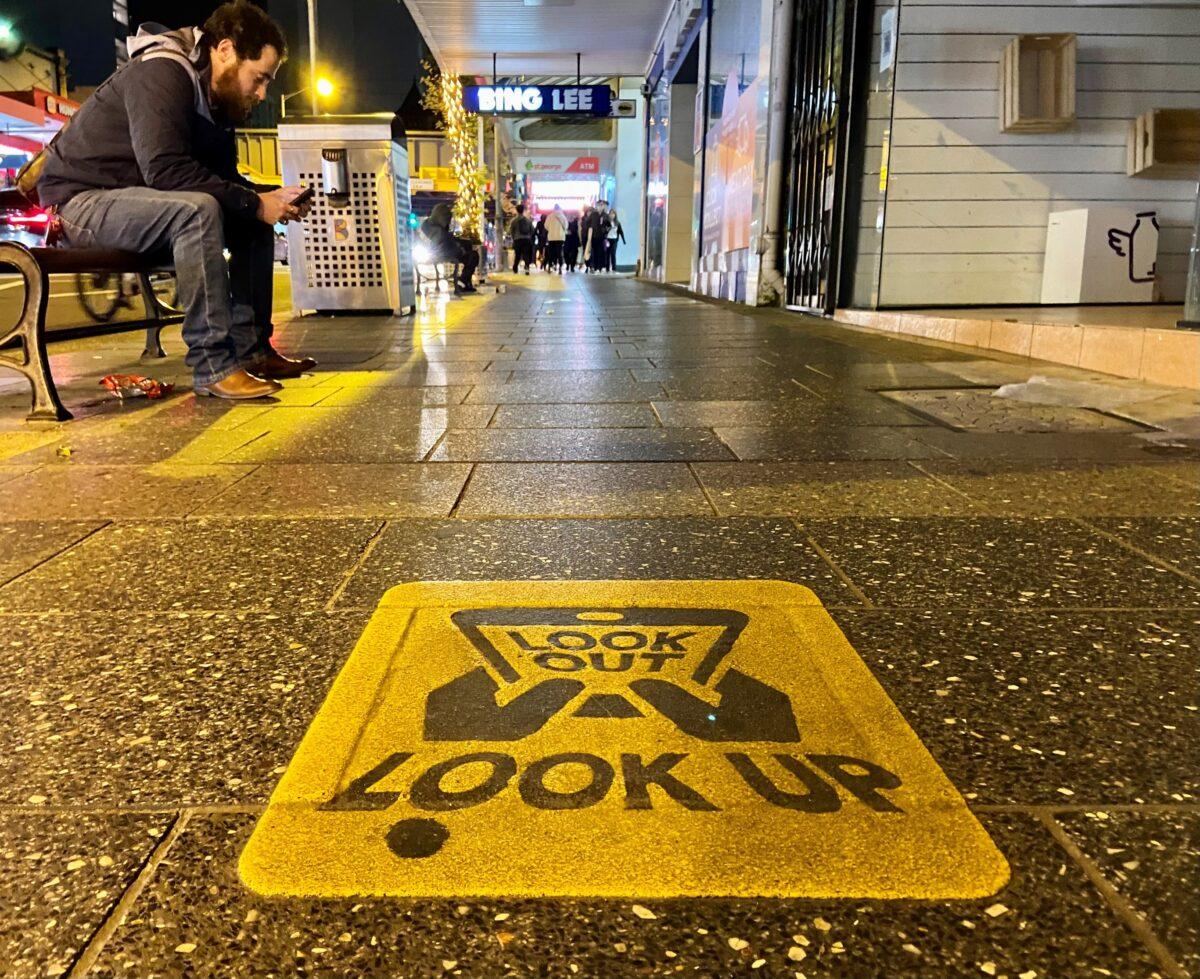 A council-sponsored sign warning smartphone users to look up when walking in Burwood, Sydney on May 7, 2023. (Daniel Teng/The Epoch Times)