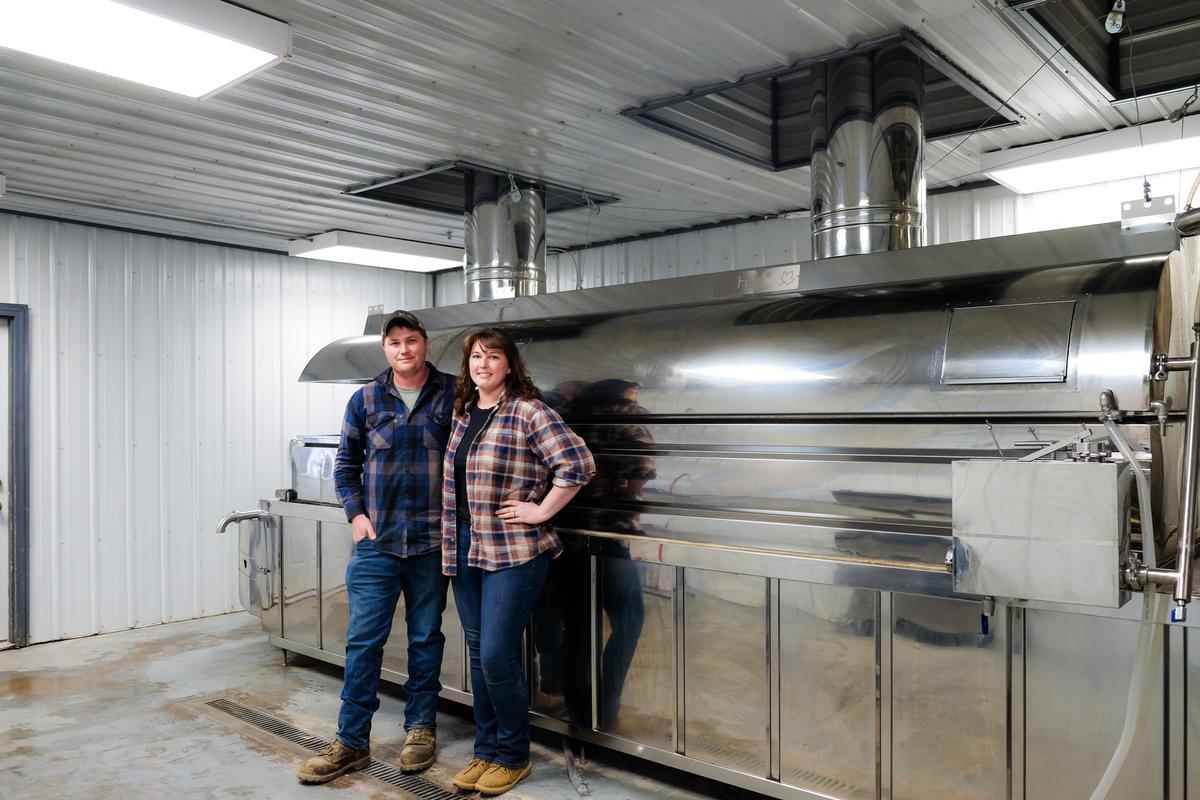 Andy and Marylin Humphrey stand in front of their massive maple syrup evaporator. (Annie Holmquist)
