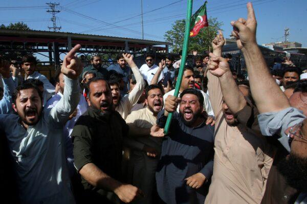 Supporters of Pakistan's former Prime Minister Imran Khan chant slogans as they block a road as a protest to condemn the arrest of their leader, in Peshawar, Pakistan, on May 9, 2023. (Muhammad Sajjad/AP Photo)