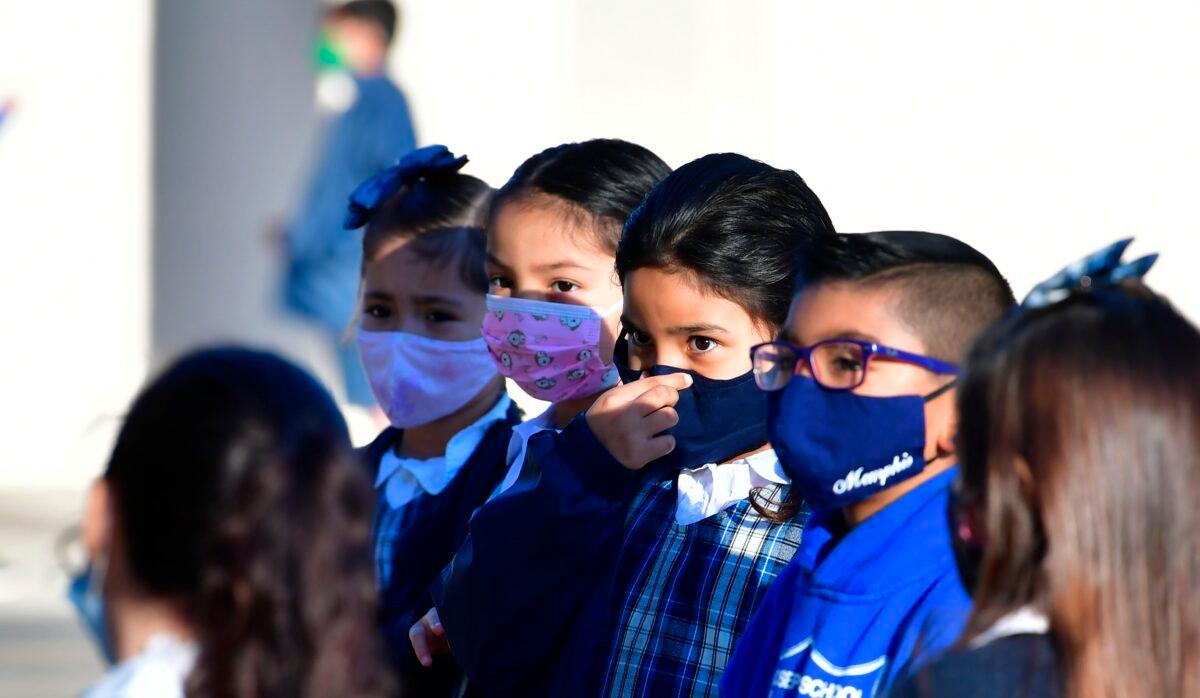 An elementary school student adjusts her mask at St. Joseph Catholic School in La Puente, Calif., on Nov. 16, 2020. (Frederic J. Brown/AFP via Getty Images)