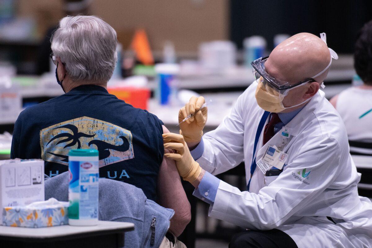 Chief clinical officer John Corman MD at Virginia Mason administers a dose of the Pfizer Covid-19 vaccine at the Amazon Meeting Center in downtown Seattle, Washington, on Jan. 24, 2021. (GRANT HINDSLEY/AFP via Getty Images)