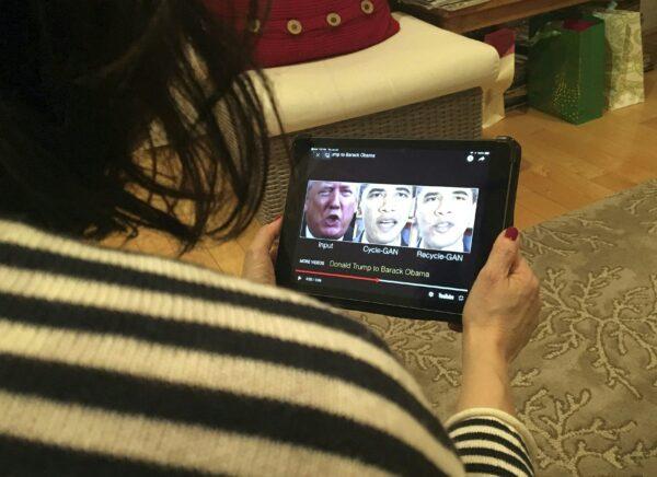 A woman views a manipulated video that changes what is said by President Donald Trump and former president Barack Obama, in Washington, on Jan. 24, 2019. (ROB LEVER/AFP via Getty Images)