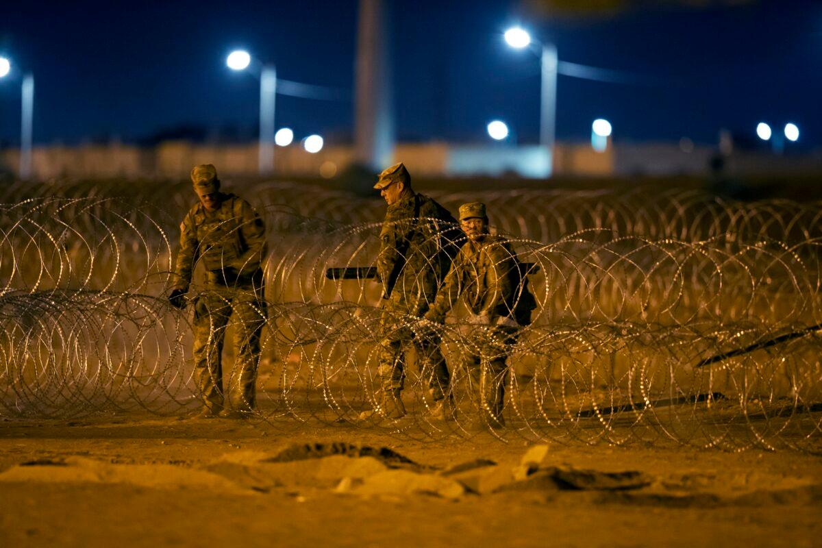 Texas National Guard soldiers install new rows of barbed-wire near a gate at the border fence in El Paso, Texas, in the early hours of May 11, 2023. (Andres Leighton/AP Photo)