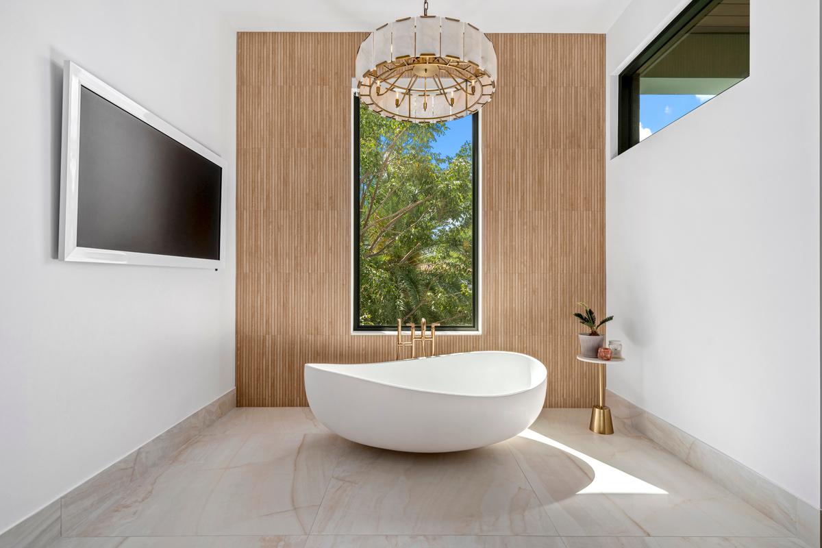 The master bath is equipped with an oversized soaking tub with a big-screen monitor to enjoy a movie during a bubble bath. (Luxury Production Studios / ONE Sotheby's International Realty)