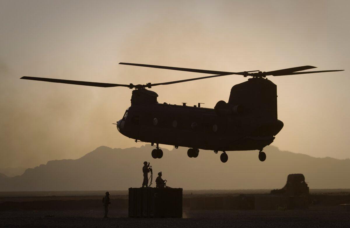 U.S. Marines direct a Chinook helicopter arriving to pick up a container with supplies at Forward Operating Base Edi in the Helmand Province of southern Afghanistan on June 9, 2011. (Anja Niedringhaus/AP Photo)