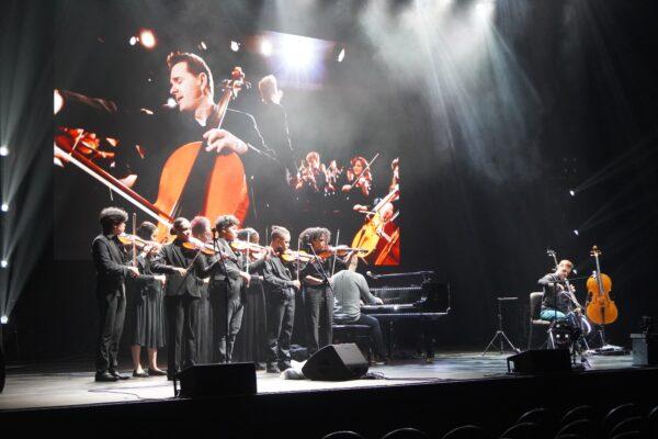 Young local violinists, invited to play during a Piano Guys concert, practice during sound check before a show in Atlanta, Ga., on Nov. 29, 2022. (Natasha Holt for The Epoch Times)